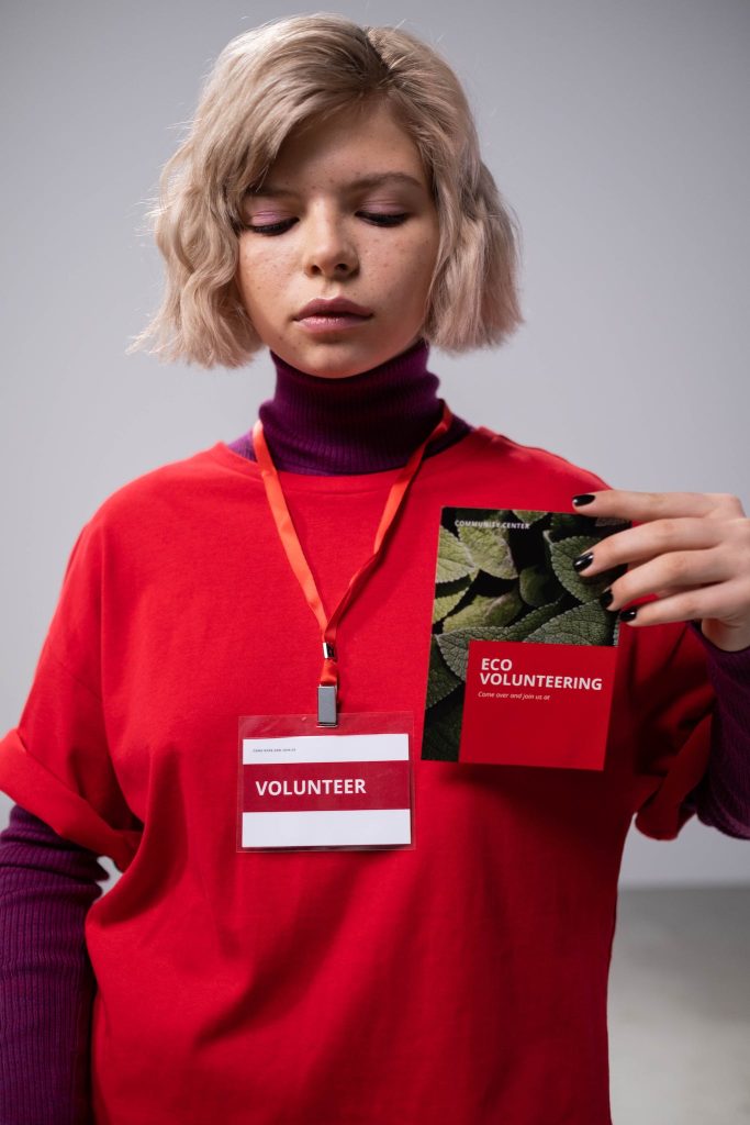 Woman in Red Top holding Red Brochure